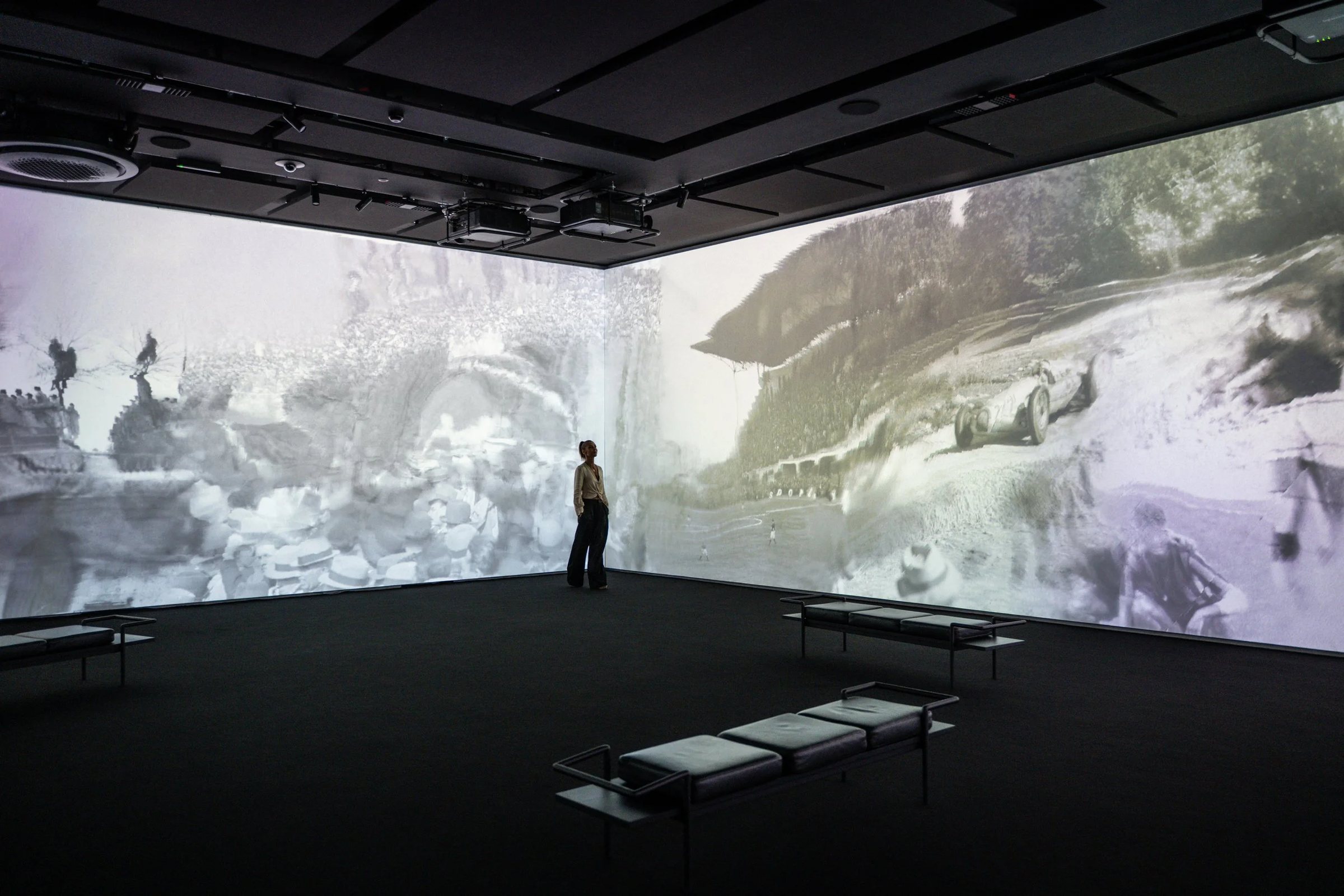 A visitor among wall-sized projections in the exhibition